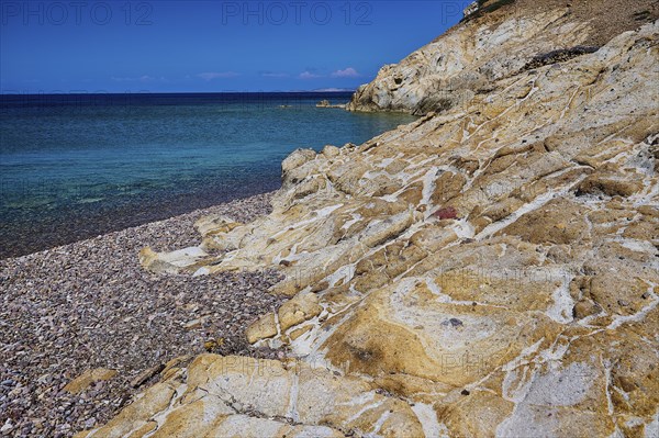 Coastal scene with rocks and blue water under a clear sky, Lambi beach, pebble beach, Patmos,