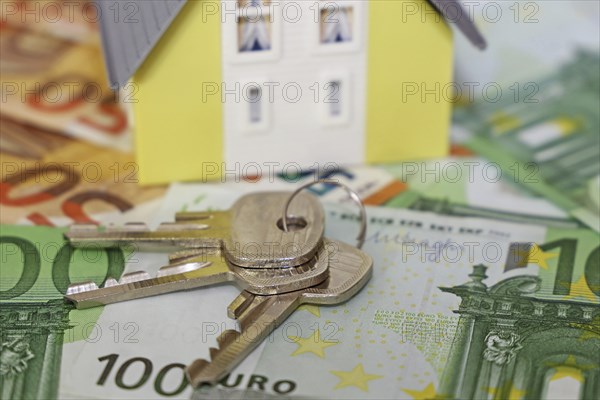 Concept photo with model house, euro notes and coins
