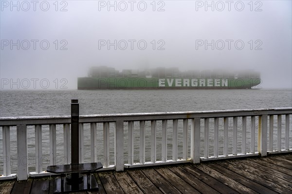 Thick fog in winter, hanging over the mouth of the Elbe into the North Sea, container ship Ever