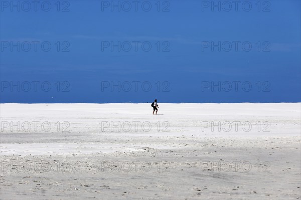 DEU, 18.06.2020, A holidaymaker walks through the knee sand on the beach of the island of Amrum,