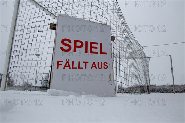 Symbolic image of a football match cancelled due to snow. Sign on a sports field with the