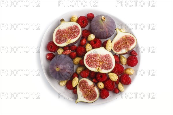Fresh figs, strawberries and raspberries on white ceramic plate isolated on white background. top