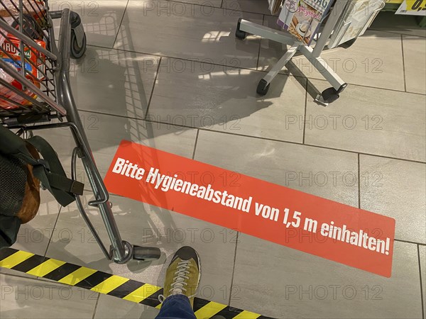 Effects of the corona crisis in Germany, sticker on the floor informs customers of a supermarket