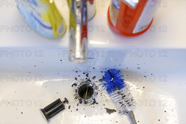 Cleaning of a sink, hand basin, bathroom, with the help of a longer brush, the dirt, deposits,