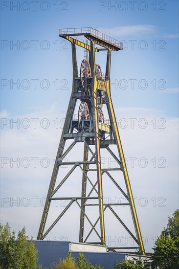 A steel winding tower surrounded by trees and blue sky, Harz Mountains, Germany, Europe