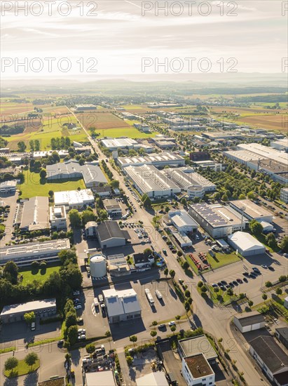 An industrial area with several factory buildings and neighbouring fields, seen from a bird's eye