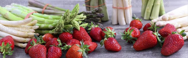 Green asparagus, white asparagus and fresh strawberries decorated on a rustic wooden table