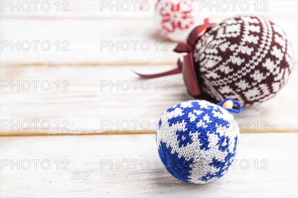 Christmas or New Year composition. Decorations, knitted balls, on a white wooden background. Side