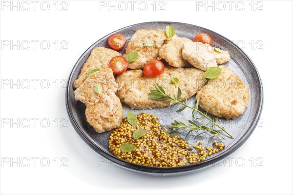 Fried pork chops with tomatoes and herbs on a gray ceramic plate isolated on white background. side