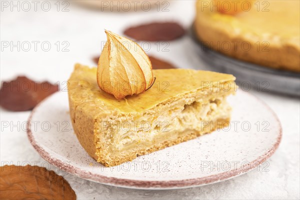 Autumn onion pie decorated with leaves and cup of coffee on gray concrete background. Side view,