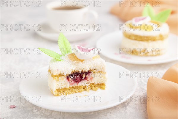 Decorated cake with milk and coconut cream with cup of coffee on a gray concrete background and