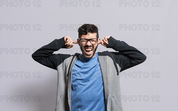 Irritated person screaming covering his ears, desperate person avoiding hearing bad news, stressed
