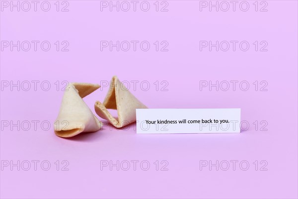 Fortune cookie with motivational text saying 'Your kindness will come back to you on pink