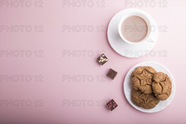 Homemade oatmeal cookies with a cup of cocoa on a pink pastel background. top view, flat lay, copy