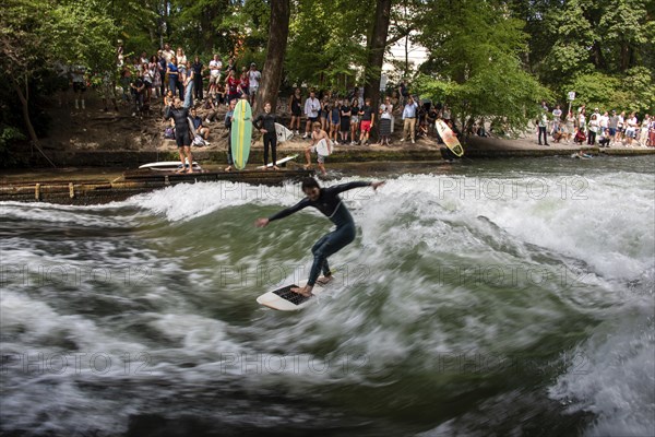 Surfers in the Eisbach, numerous onlookers on the banks, Eisbach wave in the English Garden is