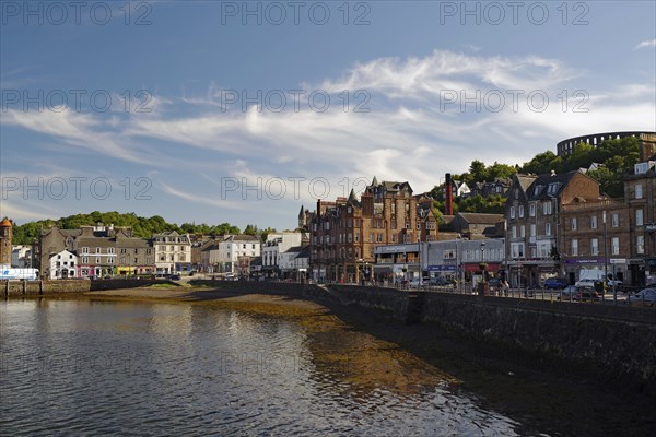 Coastal town with historic buildings along a harbour under a clear sky with some clouds, harbour