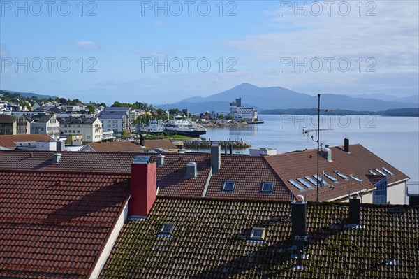 City view with red roofs of Molde, fjord landscape, sea, mountains in the background and blue,