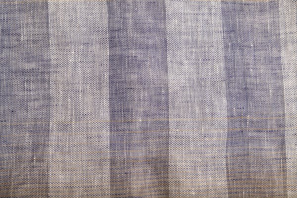 Fragment of smooth brown and violet linen tissue. Top view, flat lay, natural textile background