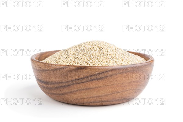 Wooden bowl with raw white quinoa seeds isolated on white background. Side view, close up
