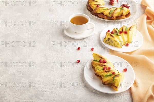 Cheesecake with cup of green tea on gray concrete background and orange linen textile. side view,