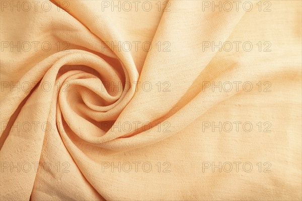 Fragment of orange linen tissue. Top view, flat lay, natural textile background and texture. wave