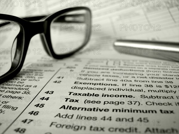 Financial Image Of Some Tax Forms With Glasses And A Pen