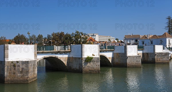 Historic white arch bridge over a quiet river in an urban landscape, Ponte Romana, Roman bridge,