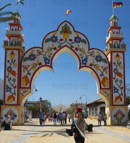 Colourful gate with floral patterns, people in the background, festive atmosphere, Feria de la