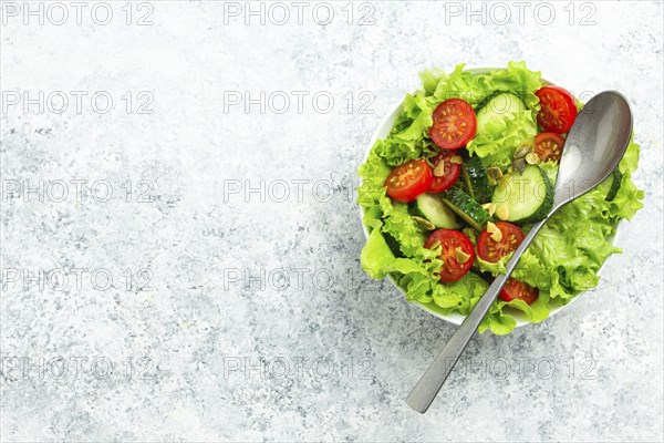 Healthy vegetables salad with fresh cucumbers, tomatoes, fresh iceberg salad leaves in a bowl on