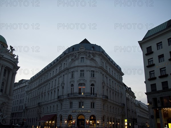 Evening street scene with illuminated facades and charming café on the corner, Vienna, Austria,