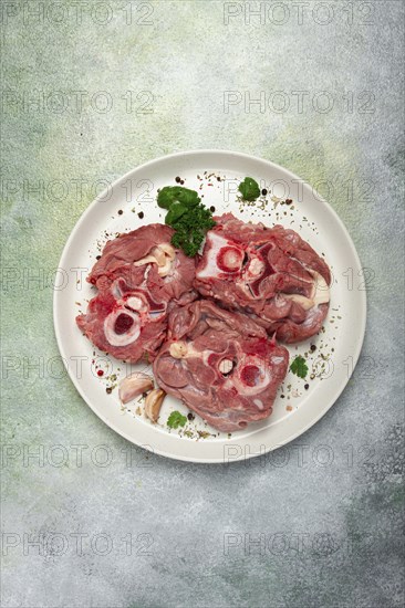 Raw steak, calf's neck on the bone, fresh meat, on a white plate, top view, no people