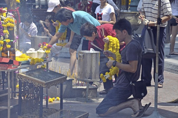 Worshippers with incense sticks at prayer, Erawan Shrine, Bangkok, Thailand, Asia