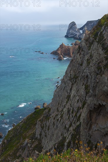 View from a cliff onto the turquoise blue sea and rocky coast, Cape Cabo da Roca, westernmost point