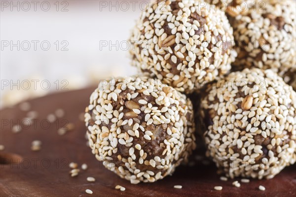 Energy balls cakes with almonds, sesame, cashew, walnuts, dates and germinated wheat on wooden