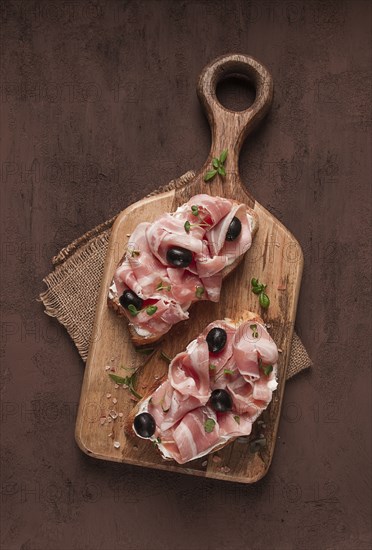 Breakfast, bacon and olives sandwich, on a cutting board, top view, close-up, no people