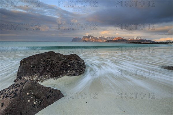 Rocks and beach in front of Bergen, sea, surf, spray, clouds, winter, Flakstadoya, Lofoten, Norway,