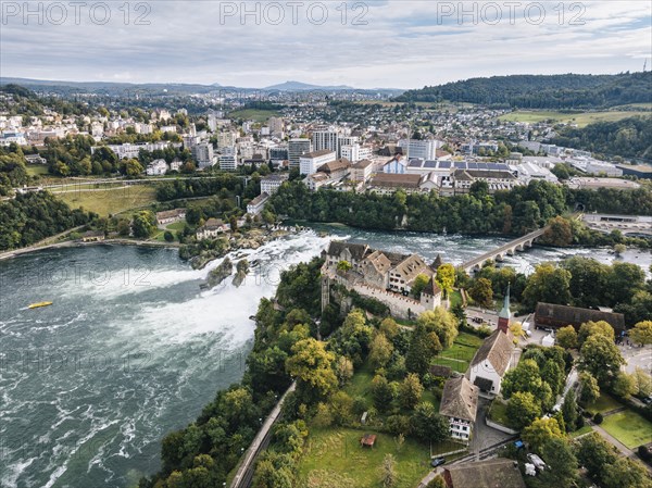 Aerial view of the Rhine Falls with Laufen Castle with autumnal vegetation, on the horizon the town