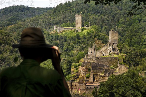 A man photographs the two castles, Oberburg and Niederburg of Manderscheid, South Eifel, Eifel,