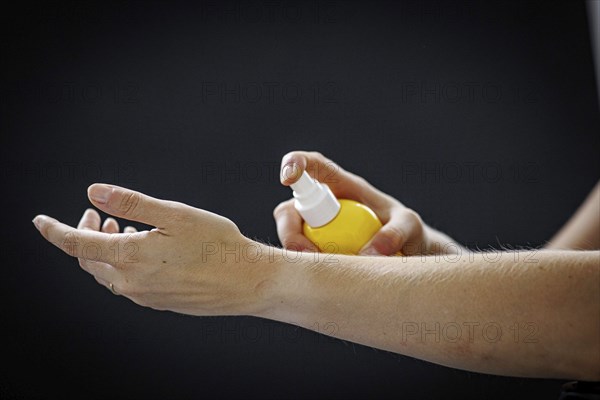 A person sprays a liquid on their arm in Berlin, 09/08/2024