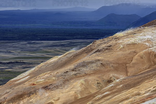 Geothermal field and sulphur springs in front of mountain landscape, clouded, Namafjall, Myvatn,
