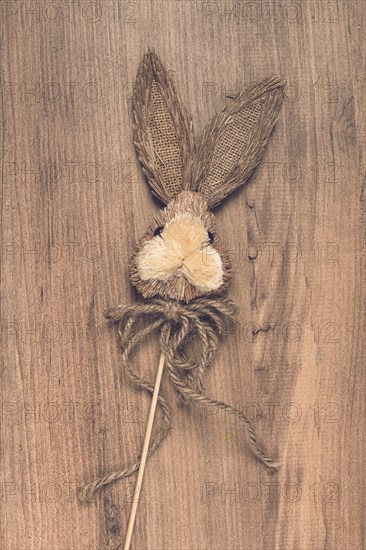 Easter bunny made of straw, on a wooden background, top view, no people