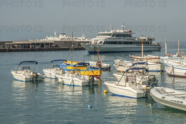 Leisure boats and incoming ferry boat in Marina Grande, Capri Island, Campania, Gulf of Naples,