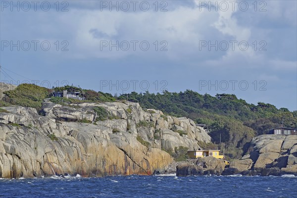 Coastal landscape with rocks, a house and wooded background under a cloudy sky, Archipelago,