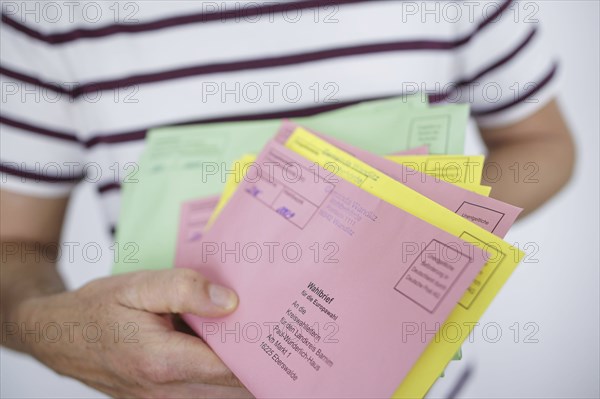 A man holds postal voting documents for the European elections, district council elections and