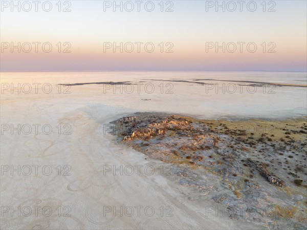 Rocky island with baobab trees in a dry salt pan, at sunset, aerial view, Kubu Island, Botswana,