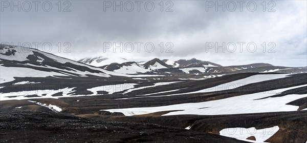 Dramatic volcanic landscape with mountains and snow, at Höskuldsskáli hut in Hrafntinnusker,