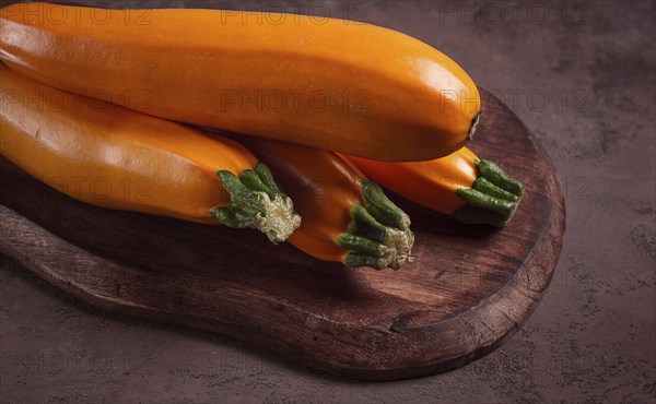 Yellow zucchini, fresh, raw, on a wooden chopping board, no people