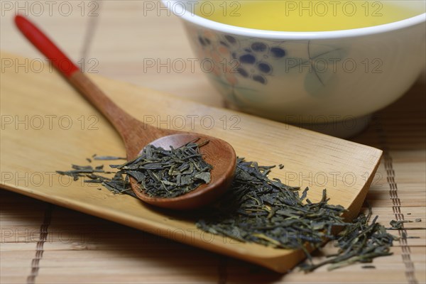 Green Sencha tea in tea bowl and tea leaves in wooden spoon, green tea, Japan, Asia