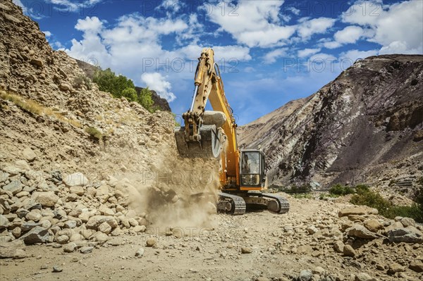 Excavator doing road construction repair in Himalayas. Ladakh, Jammu and Kashmir, India, Asia