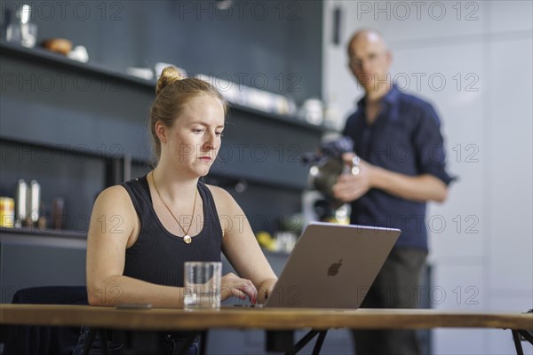 Symbolic photo on the subject of division of labour for couples in the household. A woman sits at a